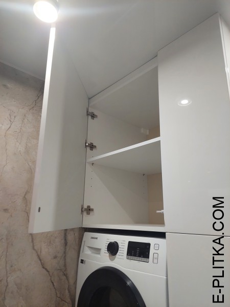 Стиральная машина спрятанная во встроенной мебели для ванной