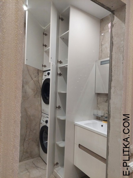 Стиральная машина спрятанная во встроенной мебели для ванной