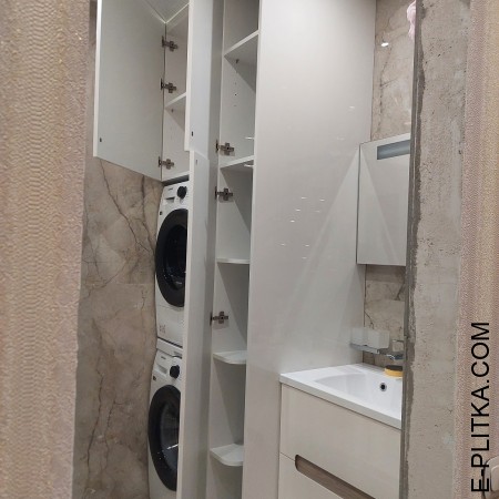 Стиральная машина спрятанная во встроенной мебели для ванной