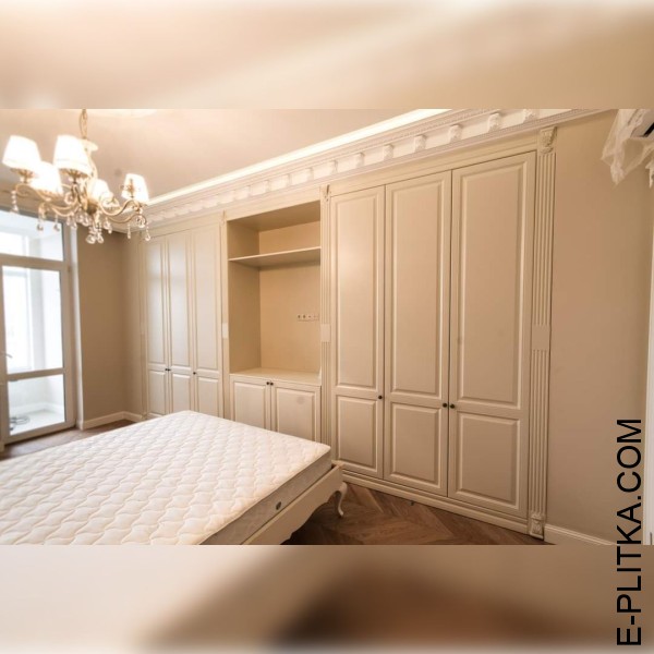 Шафа вбудована в класичну спальню світлих тонів