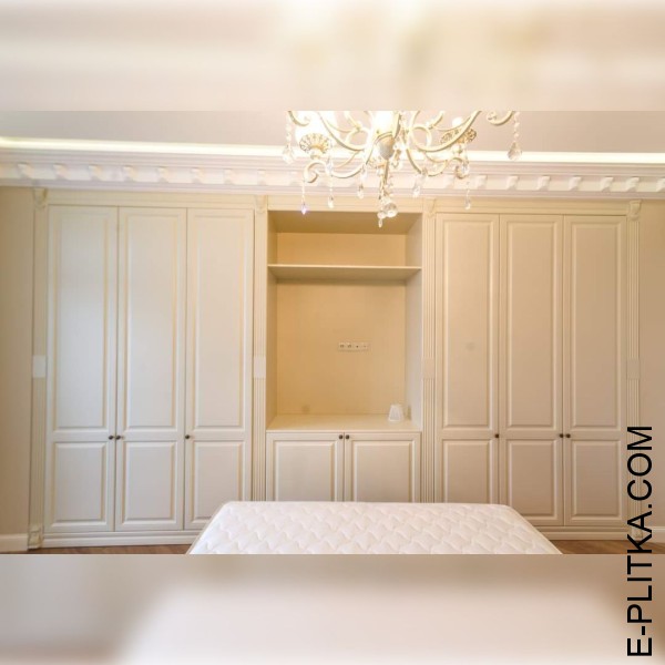 Шафа вбудована в класичну спальню світлих тонів