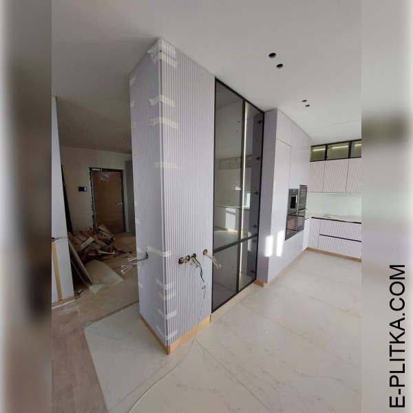 Кухня з рифленими білими фасадами та рамковими скляними шафами.